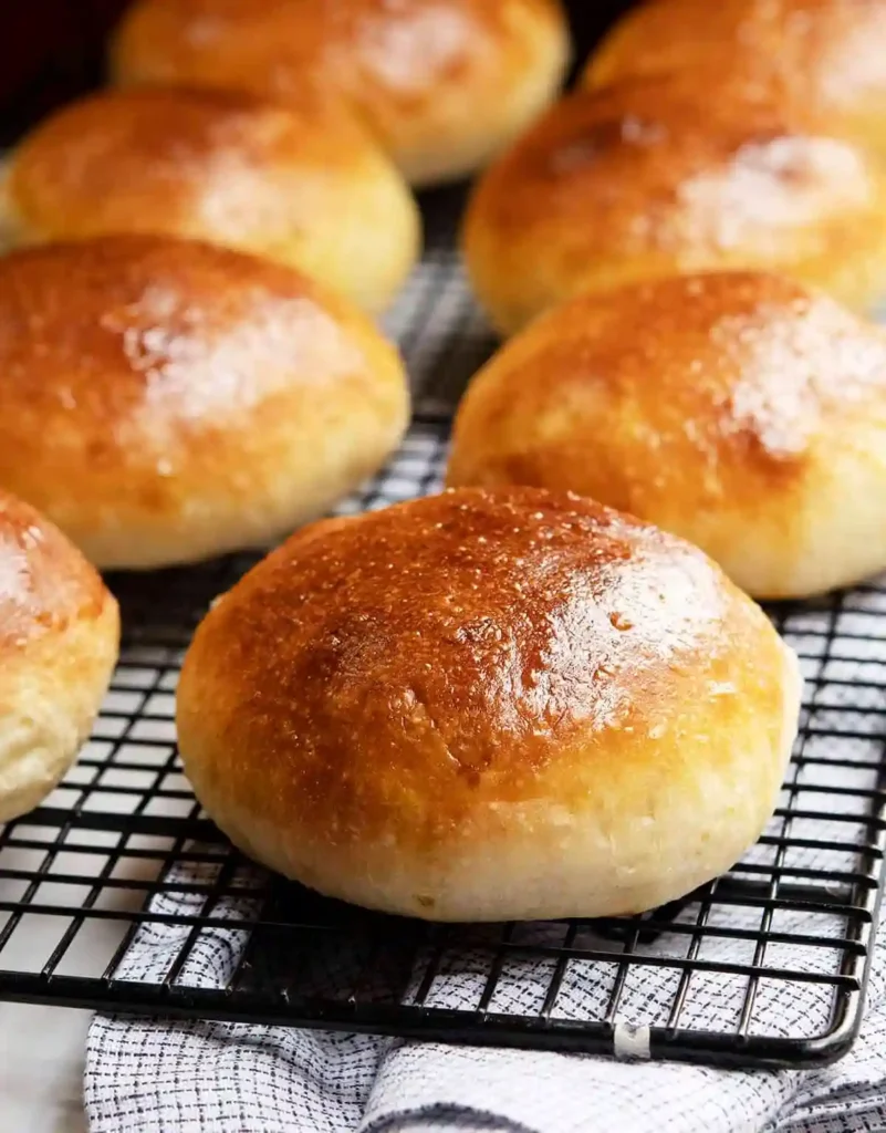 Frisch gebackene Brioche Brötchen mit glänzender Kruste auf einem Gitterrost