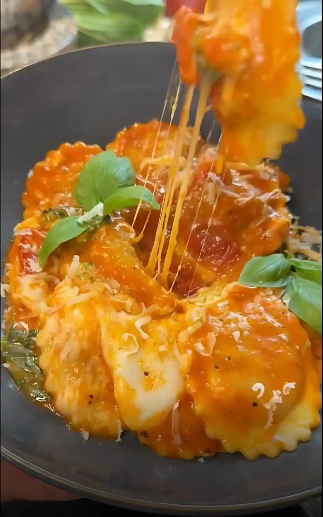 Cheesy Ravioli mit Tomatensauce und Mozzarella, der herrlich Fäden zieht, verfeinert mit frischem Basilikum – schnelle Sauce zu Ravioli.