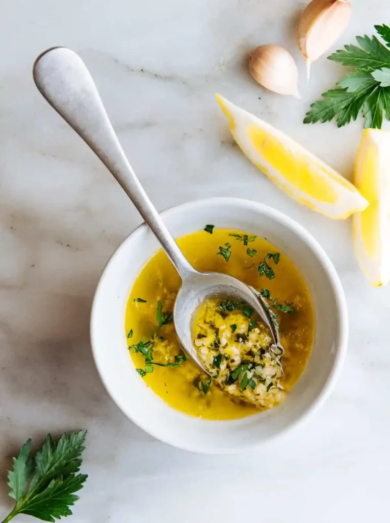 Zitronen-Knoblauch-Butter-Soße in Schälchen mit Löffel – eine einfache, frische Variante unter den leckeren Soßen für Pasta und schnellen Nudelsoßen Rezepten.