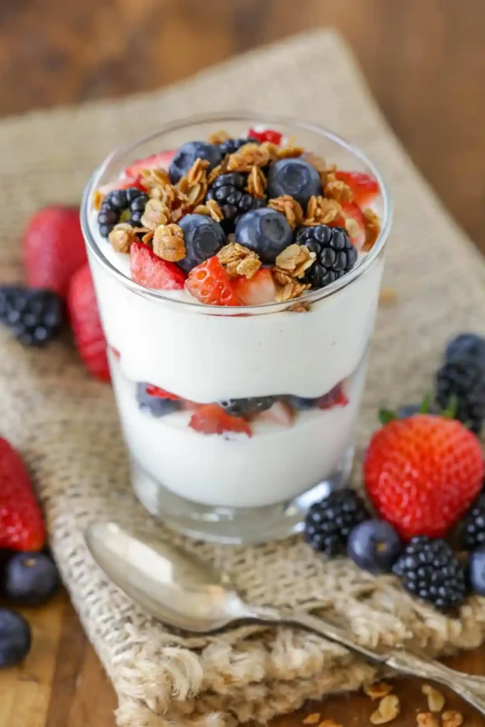 Joghurt-Beeren-Dessert im Glas mit frischen Erdbeeren, Blaubeeren, Brombeeren und knusprigem Granola – ein schneller süßer Snack mit wenig Zutaten.