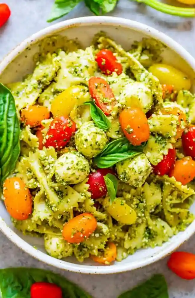 Frischer Pesto-Nudelsalat mit Tomaten und Mozzarella als essen zum mitnehmen arbeit kalt.