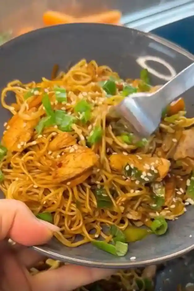 Schüssel mit asiatischen gebratenen Nudeln mit Hähnchen, Gemüse, Sesam und Sojasauce