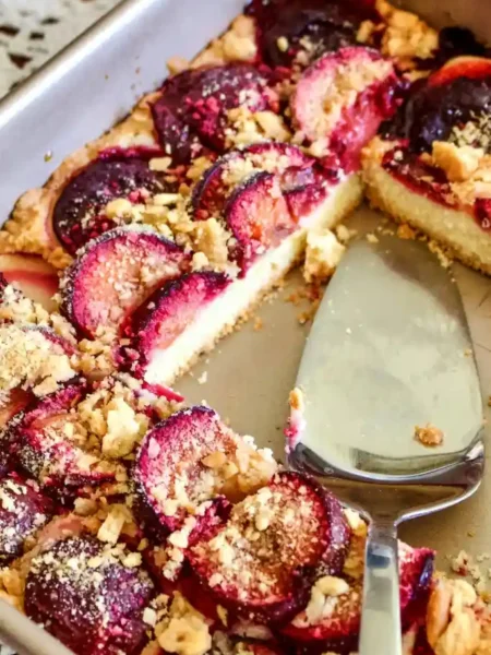 Frisch gebackener Pflaumenkuchen auf dem Blech mit Streusel, saftig und knusprig