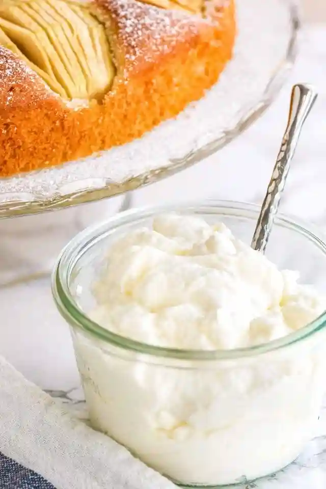 Versunkener Apfelkuchen mit Schlagsahne serviert – klassisches Oma Rezept