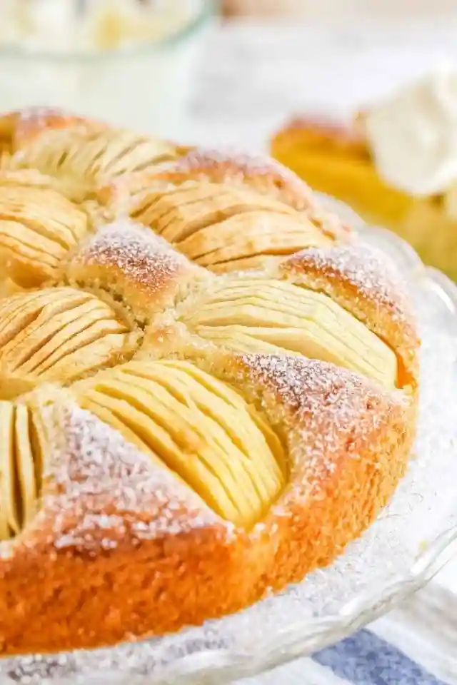 Versunkener Apfelkuchen nach Omas Rezept mit Rührteig und Apfelspalten, bestäubt mit Puderzucker