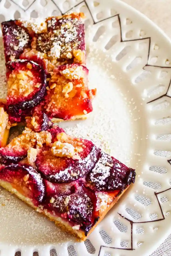 Nahaufnahme von Pflaumenkuchen auf dem Blech mit Streusel auf Teller