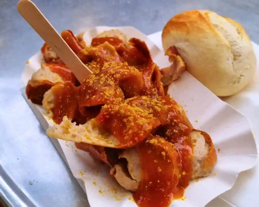 Currywurst mit Brötchen und würziger Currywurst Soße Rezept serviert im Pappteller