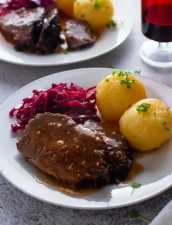 Traditioneller deutscher Sauerbraten mit Rotkohl und Kartoffelklößen – klassisches Sauerbraten Rezept