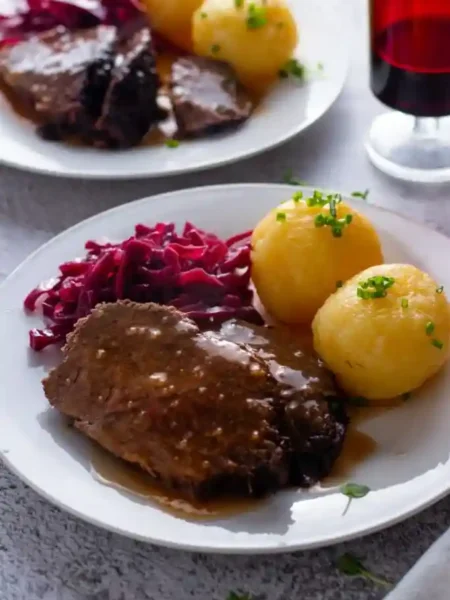 Traditioneller deutscher Sauerbraten mit Rotkohl und Kartoffelklößen – klassisches Sauerbraten Rezept