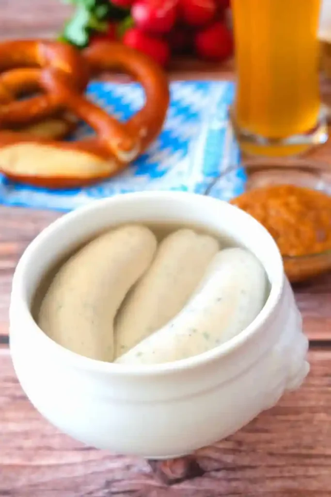 Bayerische Weißwurst im Terrine serviert – traditionell mit Brezel, süßem Senf und Weißbier