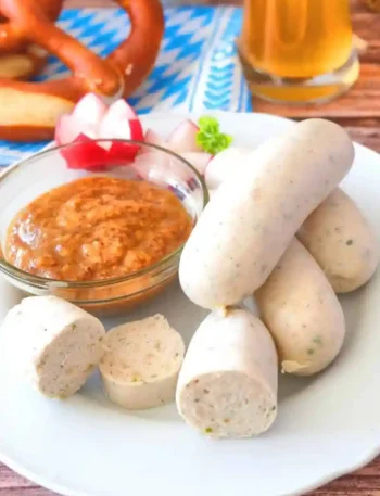 Weißwurst kochen und zubereiten mit süßem Senf, Brezel und Bier – traditionelles bayerisches Rezept