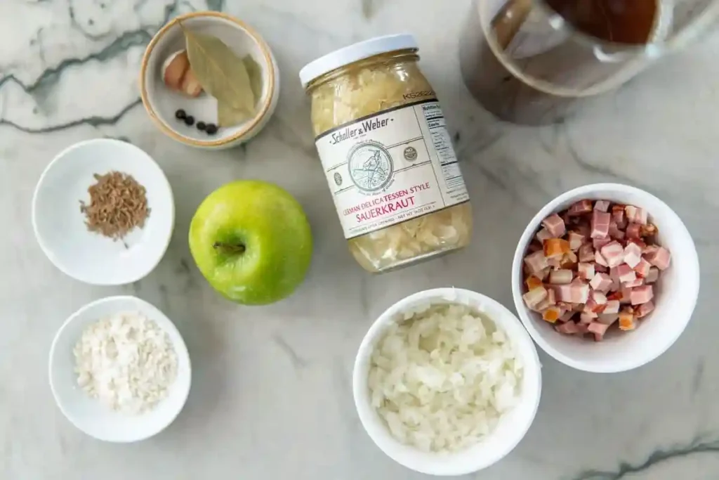 Zutaten für Sauerkraut kochen mit Speck und Zwiebeln – Apfel, Speck, Sauerkraut, Zwiebeln und Gewürze