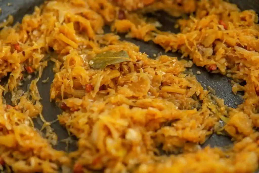 Sauerkraut kochen mit Speck und Zwiebeln in der Pfanne