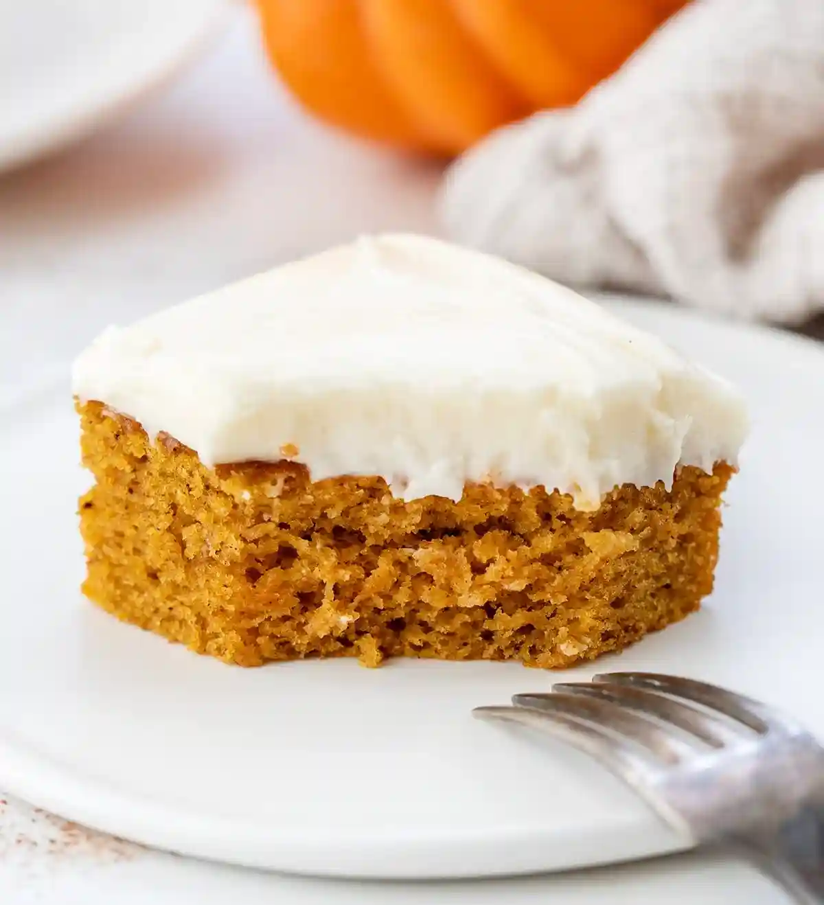 Kürbiskuchen vom Blech mit Frischkäse Frosting auf weißem Teller