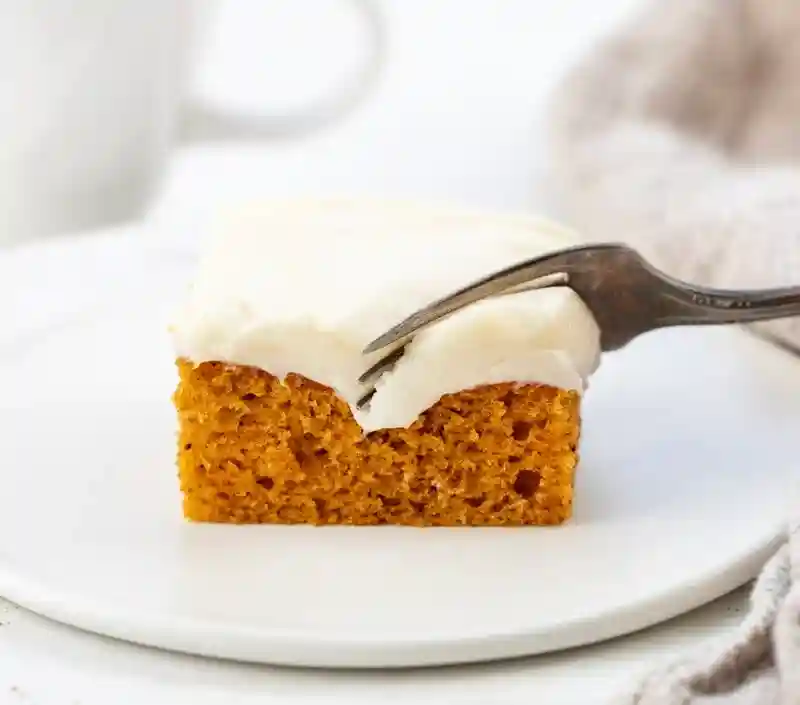 Kürbiskuchen vom Blech mit Frischkäse Frosting auf Teller mit Gabel