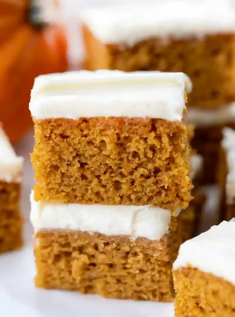Kürbiskuchen vom Blech mit Frischkäse Frosting in Stücke geschnitten