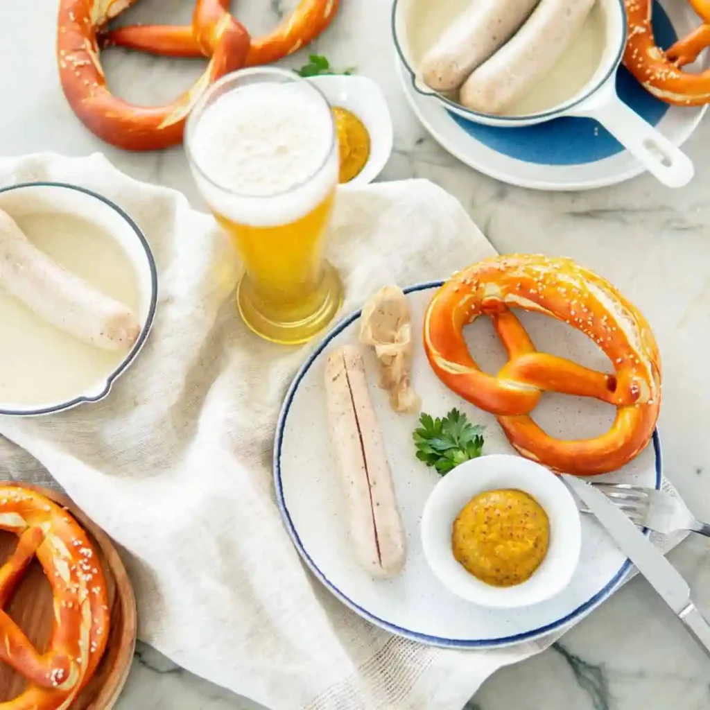 Weißwurst zubereiten mit Brezel, süßem Senf und Weißbier – traditionelles bayerisches Frühstück