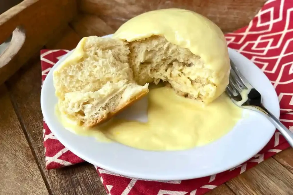 Fluffige Dampfnudeln mit Vanillesoße auf Teller serviert