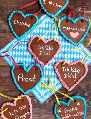 Selbstgemachtes Lebkuchenherz mit bunter Zuckerguss Dekoration – verschiedene Lebkuchenherzen mit Sprüchen wie „Ich liebe Dich“ und „Frohe Weihnachten“.