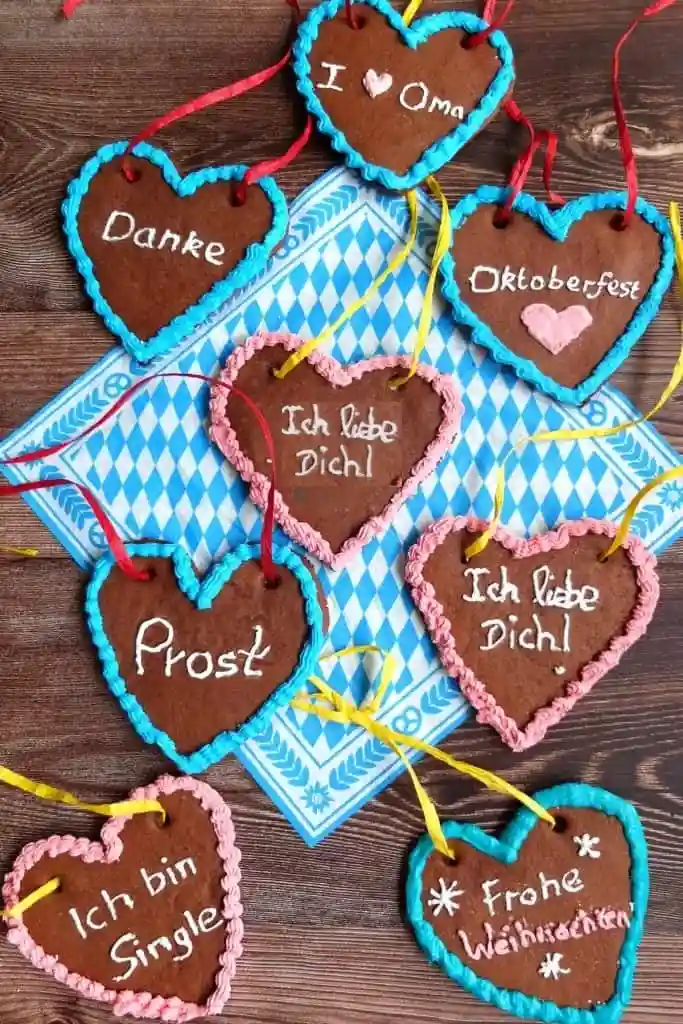 Selbstgemachtes Lebkuchenherz mit bunter Zuckerguss Dekoration – verschiedene Lebkuchenherzen mit Sprüchen wie „Ich liebe Dich“ und „Frohe Weihnachten“.
