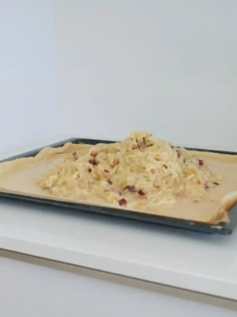 Zwiebel-Speck-Mischung auf Hefeteig verteilen – Zwiebelkuchen vom Blech