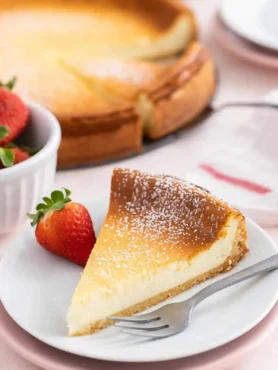 Klassischer Käsekuchen mit Quark – cremiger gebackener Käsekuchen mit Boden, serviert als Kuchenstück mit Erdbeeren