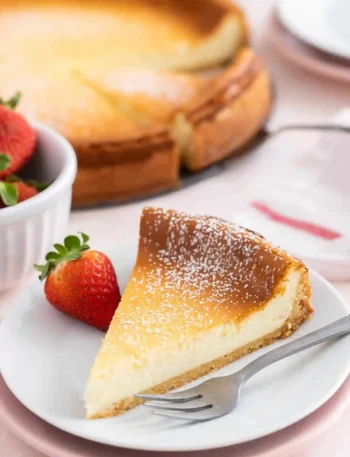 Klassischer Käsekuchen mit Quark – cremiger gebackener Käsekuchen mit Boden, serviert als Kuchenstück mit Erdbeeren