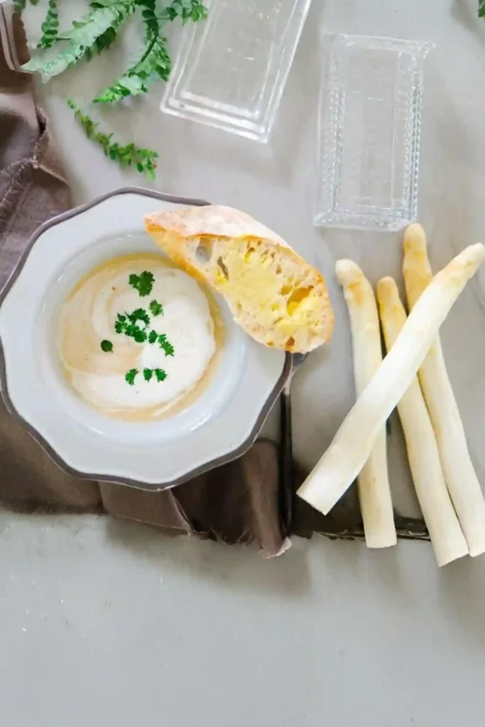 Spargelsuppe Rezept – cremige Spargelcremesuppe mit Brot und weißem Spargel angerichtet