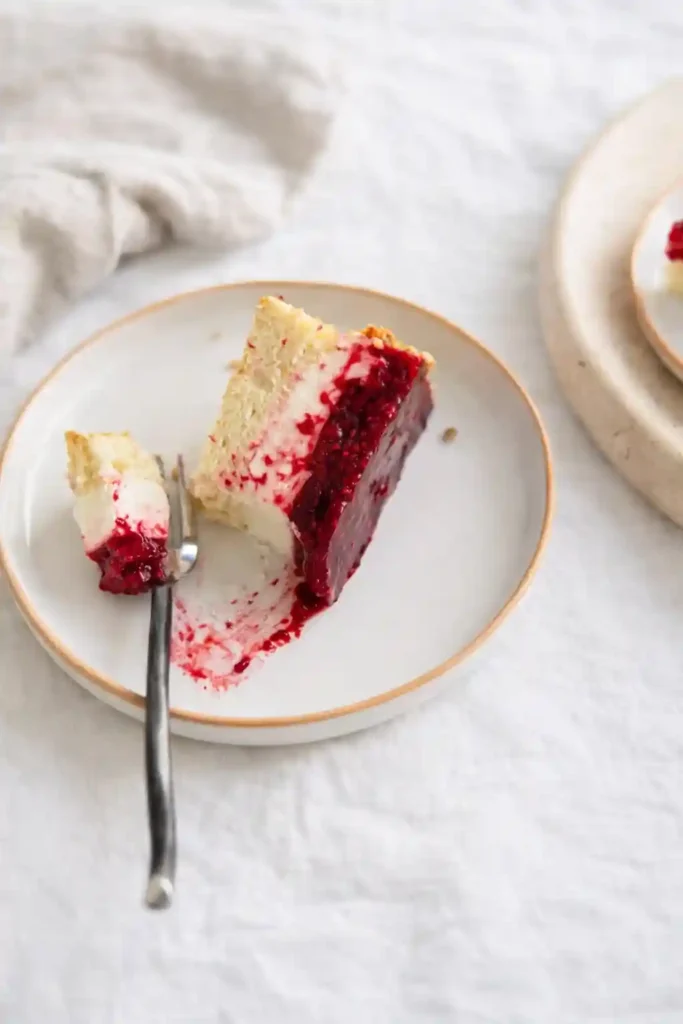Stück Himbeertorte mit Sahne auf Teller – einfache Himbeer-Sahne-Torte mit luftigem Biskuit und fruchtiger Himbeerfüllung