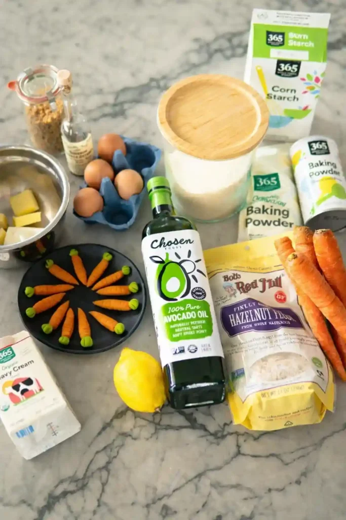 Zutaten für Karottenkuchen und Rüblikuchen mit Nüssen, Karotten, Eiern, Öl und Frischkäse-Frosting