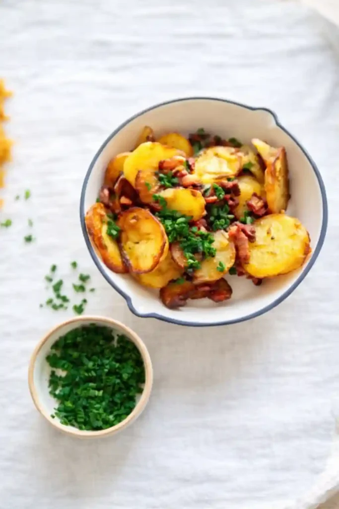 Knusprige Bratkartoffeln mit Speck und Zwiebeln in einer Schüssel