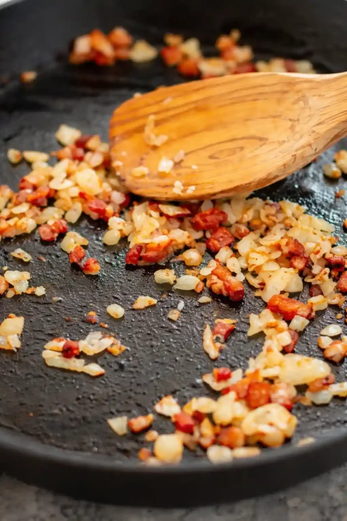 Speck und Zwiebeln anbraten für knusprige Bratkartoffeln Rezept