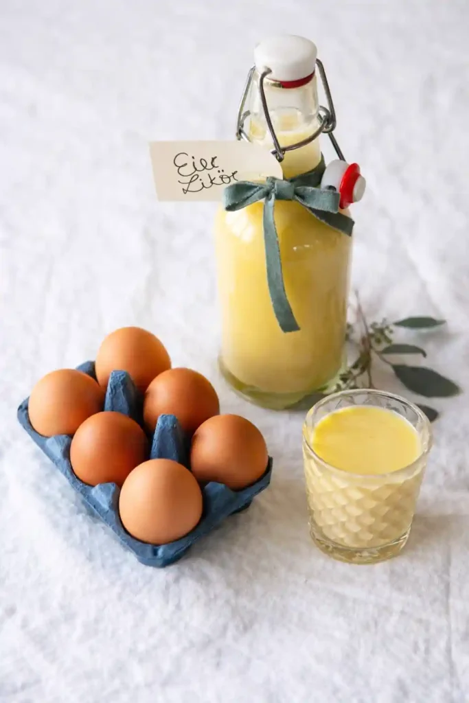 Omas Eierlikör Rezept DDR – selbstgemachter Eierlikör mit Rum in Flasche und Glas neben frischen Eiern