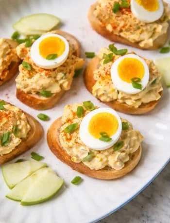 Omas Eiersalat DDR Rezept mit Mayonnaise und Joghurt, serviert auf Baguette mit Schnittlauch und gekochtem Ei