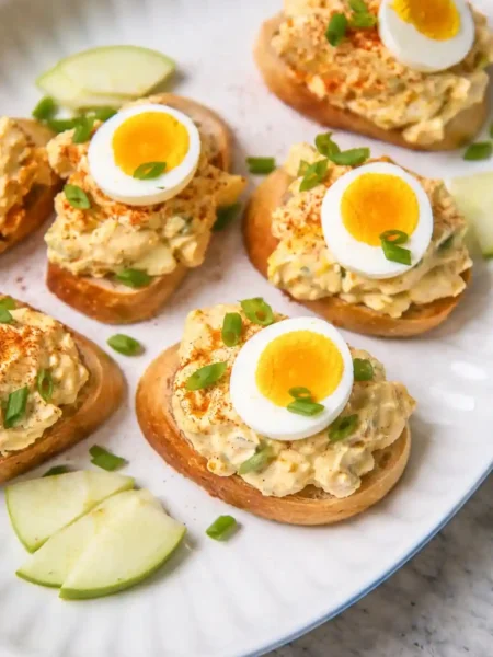 Omas Eiersalat DDR Rezept mit Mayonnaise und Joghurt, serviert auf Baguette mit Schnittlauch und gekochtem Ei