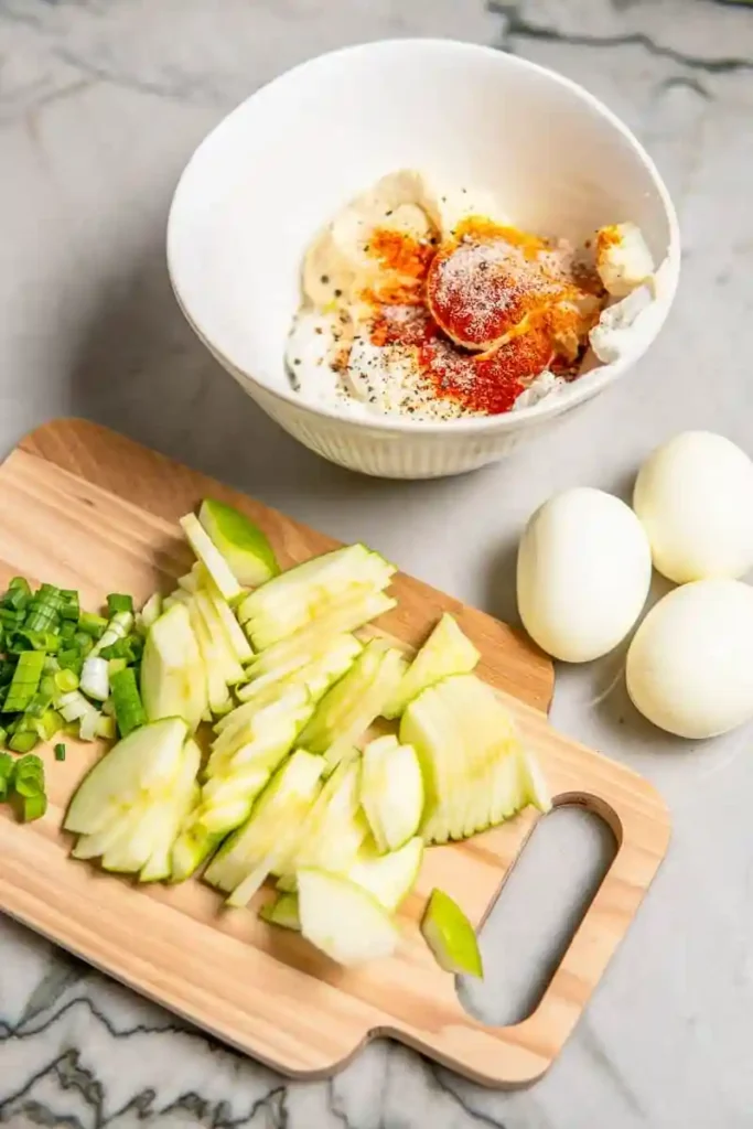 Zubereitung für Omas Eiersalat DDR Rezept mit Mayonnaise und Joghurt – geschnittener Apfel, Schnittlauch und Gewürze