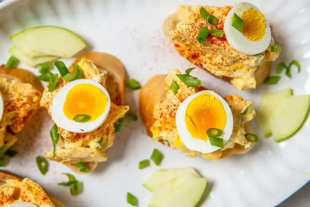 Omas Eiersalat DDR Rezept mit Mayonnaise und Joghurt, serviert auf Brot mit Schnittlauch und gekochtem Ei