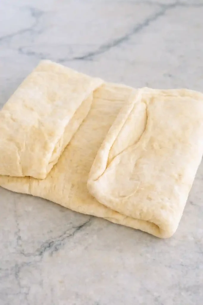 Plunderteig Rezept – Plunderteig beim Tourieren gefaltet für Croissant Teig selber machen