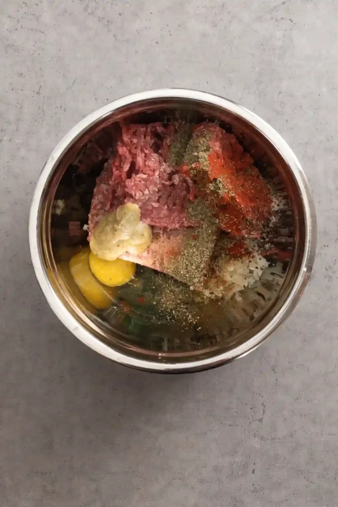 Saftige Frikadellen Rezept mit Paniermehl nach Omas Art – Hackfleisch, Ei, Senf und Gewürze in einer Schüssel