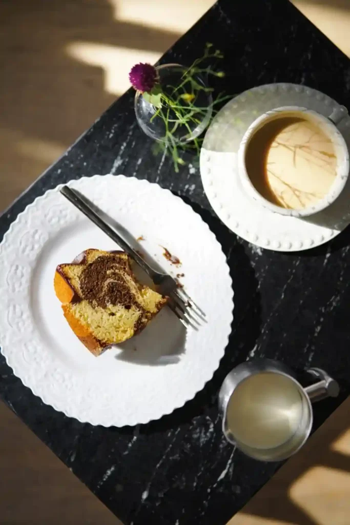 Saftiger Marmorkuchen Rezept als Gugelhupf – Omas Marmorkuchen saftig und locker als Stück mit Kaffee serviert