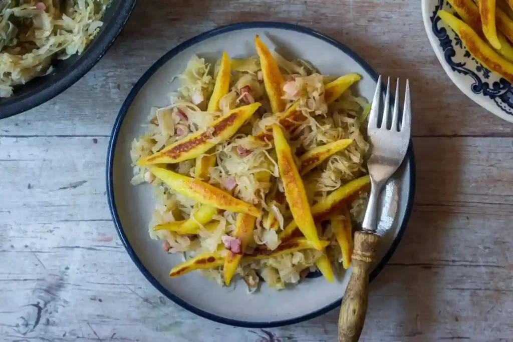 Schupfnudeln Rezept mit Sauerkraut und Speck aus der Pfanne – knusprige Schupfnudel Sauerkraut Pfanne auf dem Teller
