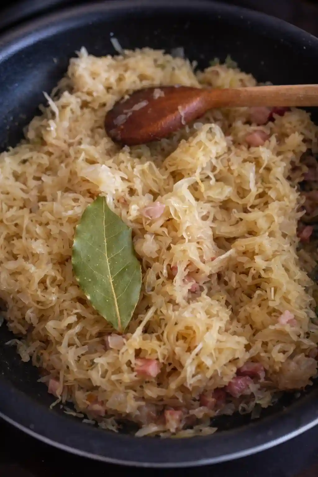 Geschmortes Sauerkraut mit Speck in der Pfanne – Schritt im Schupfnudeln Rezept mit Sauerkraut und Speck