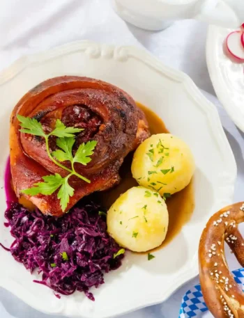 Bayerische Schweinshaxe im Backofen mit Vorkochen, knusprige Haxe im Ofen mit Rotkohl, Kartoffelklößen und Bratensoße