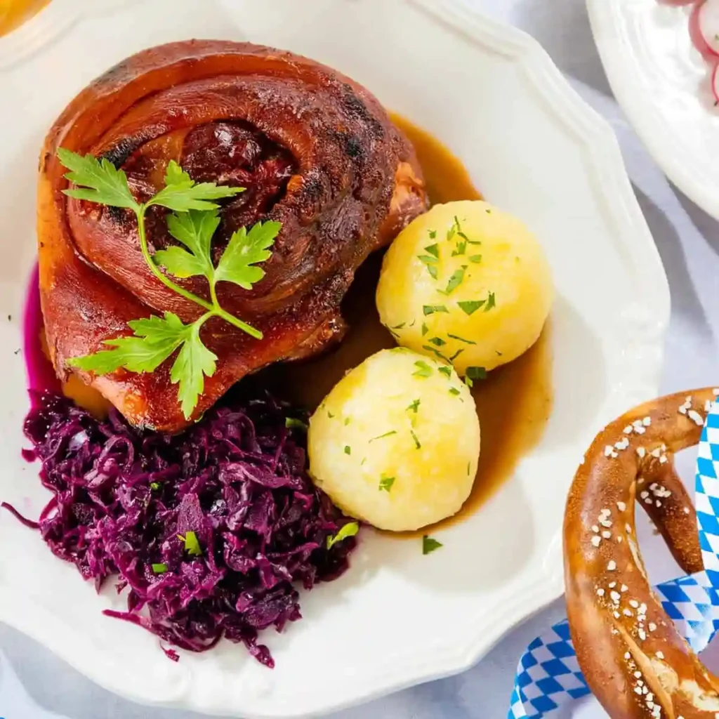 Bayerische Schweinshaxe im Backofen mit Vorkochen, knusprige Haxe mit Rotkohl, Kartoffelklößen und Soße