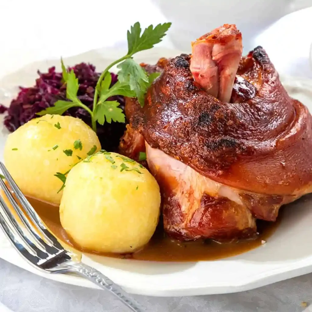Schweinshaxe im Backofen mit Vorkochen, knusprige bayerische Haxe mit Kartoffelklößen und Rotkohl
