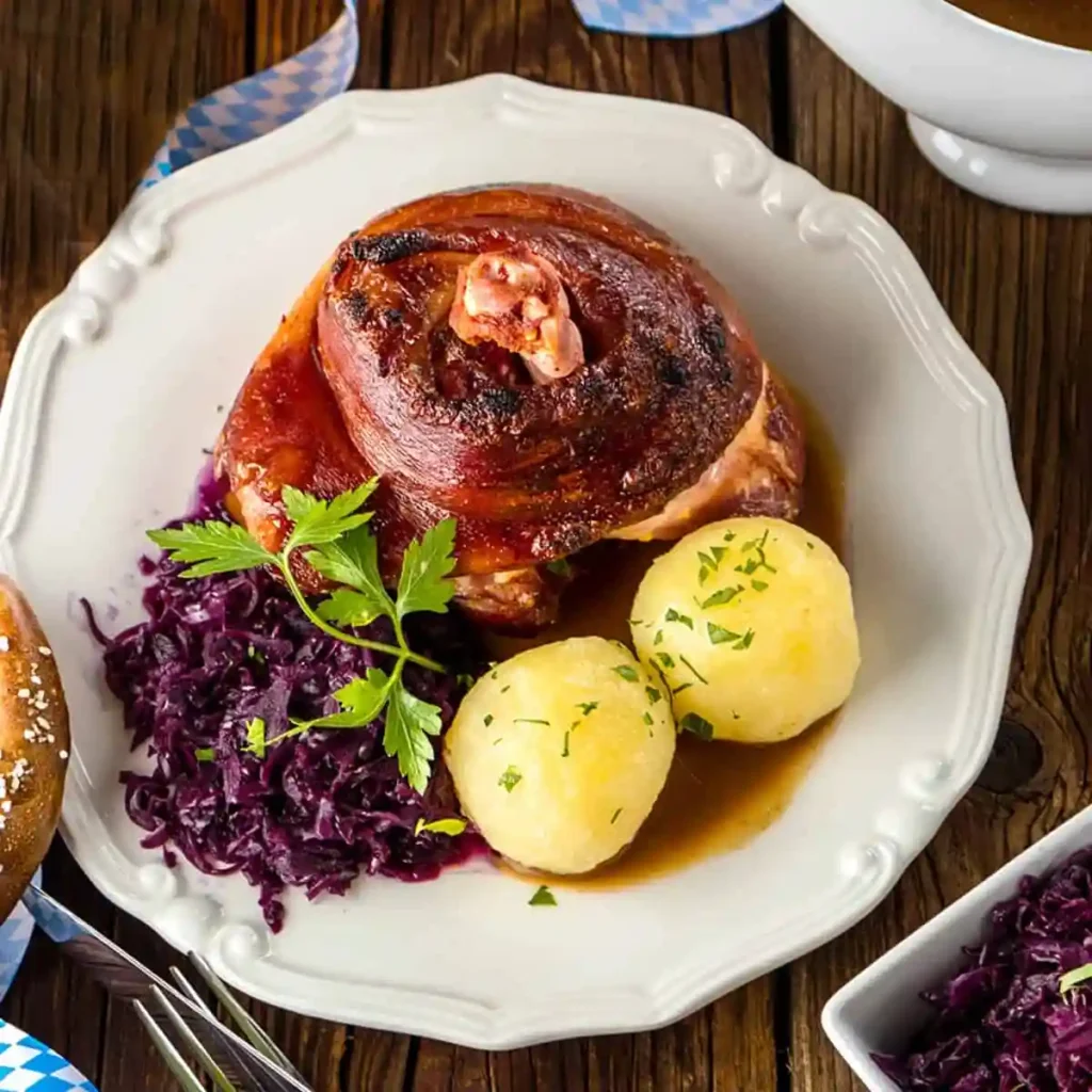 Knusprige Schweinshaxe im Backofen mit Vorkochen, bayerische Haxe mit Rotkohl, Kartoffelklößen und Bratensoße