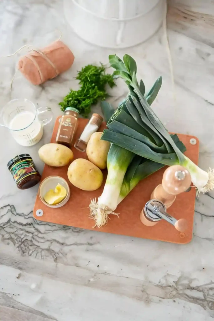 Zutaten für vegetarische Lauchcremesuppe mit Lauch und Kartoffeln auf einem Schneidebrett