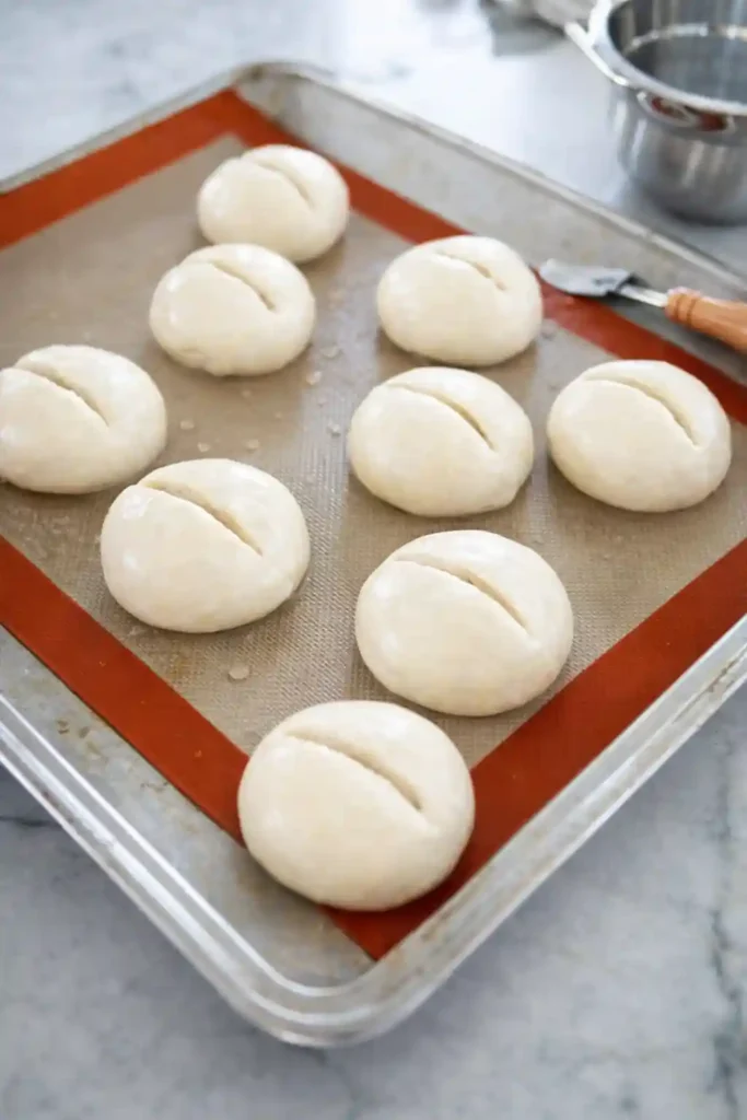 Eingeschnittene Teiglinge für Weizenbrötchen Rezept auf dem Backblech – Weizenbrötchen selber backen Schritt