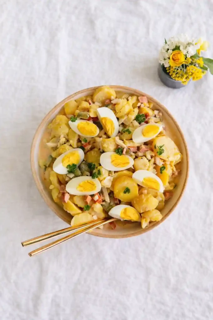 Omas Kartoffelsalat mit Wiener Würstchen und Mayonnaise in einer Schüssel – klassischer Kartoffelsalat mit Würstchen und Ei