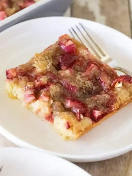 Erdbeer Rhabarber Kuchen vom Blech auf einem Teller serviert – saftiger Blechkuchen mit Erdbeeren und Rhabarber